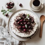 Whole Black Forest Cheesecake Cake topped with whipped cream and cherries